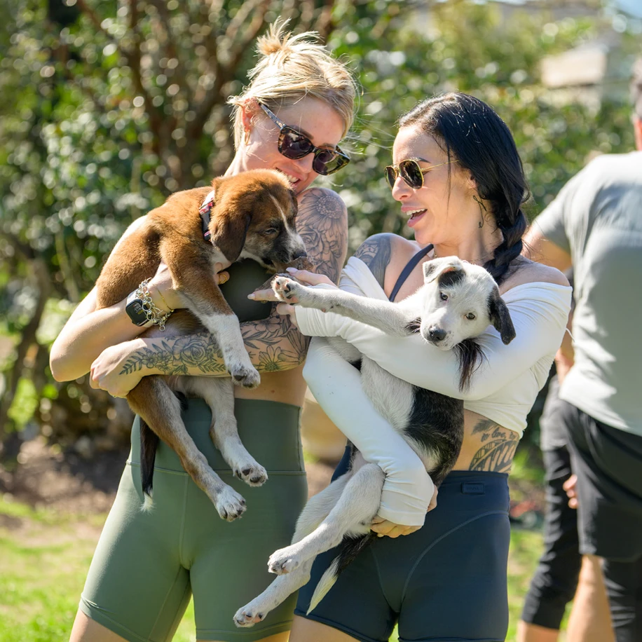 Volunteers holding rescue puppies at a Crystal Coast Dog Club event